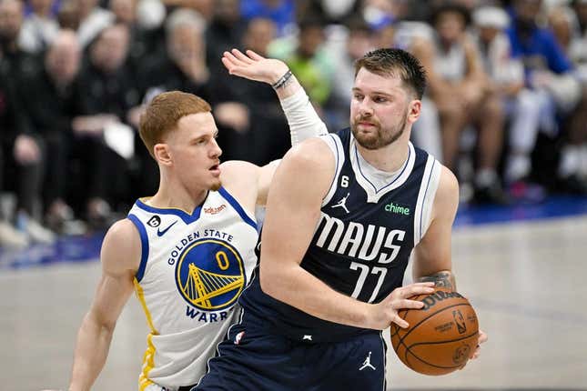 Mar 22, 2023; Dallas, Texas, USA; Golden State Warriors guard Donte DiVincenzo (0) and Dallas Mavericks guard Luka Doncic (77) in action during the game between the Dallas Mavericks and the Golden State Warriors at the American Airlines Center.