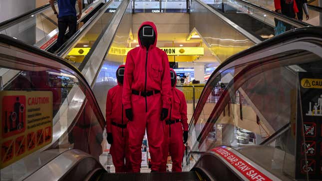 Cosplayers dressed in outfits from the Netflix series “Squid Game” ride an escalator at a shopping mall in Kuala Lumpur on October 20, 2021.