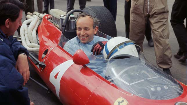 John Surtees in conversation as he sits behind the wheel of his Ferrari