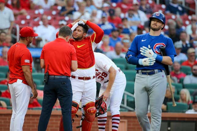 A trainer tends to St. Louis Cardinals catcher Willson Contreras after he was hit by bat of Chicago Cubs' Ian Happ
