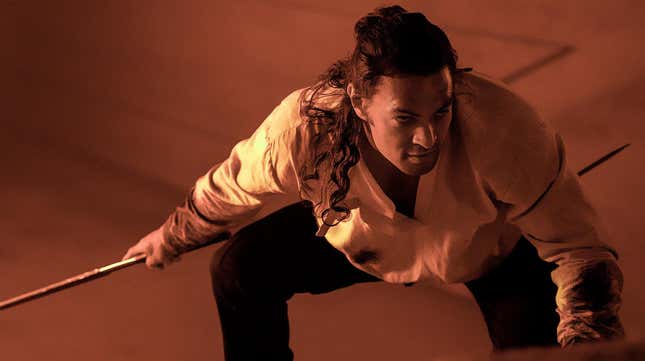 Momoa posing with a weapon in a scene from Dune.