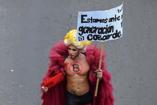 A person holding a banner that reads “We are facing a generation of cowards” takes part in a demonstration against the circulation of bitcoin in San Salvador, on September 7, 2021. 