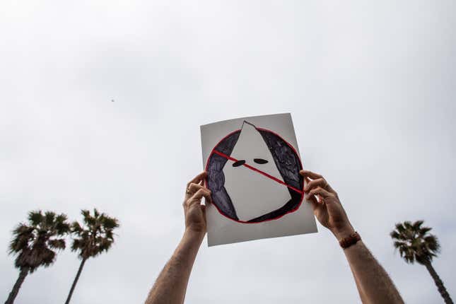 HUNTINGTON BEACH, CA - APRIL 11: Joe Cook Gines holds an anti-Ku Klux Klan placard at Huntington Beach pier during a protest against white supremacy on April 11, 2021