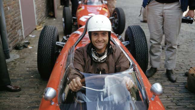 Phil Hill smiles behind the wheel of a Ferrari
