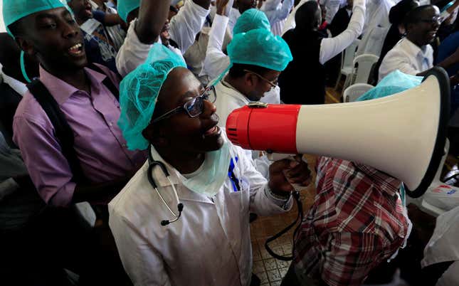 A Kenyan doctor uses a megaphone to shout demands.