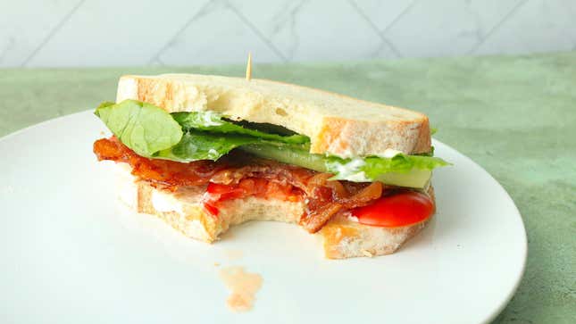 A BLT on untoasted soft rye bread on a plate