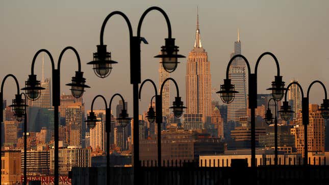 A photo of lamp posts in front of the Manhattan skyline.