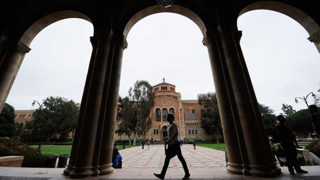 Student walks under pillars on university campus