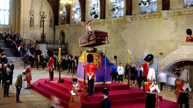 Image for article titled Brits Take Turns Mourning Atop Queen’s Bucking Casket