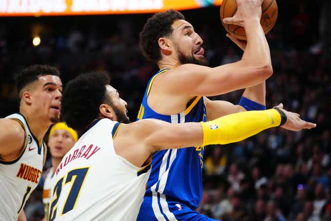 Apr 2, 2023; Denver, Colorado, USA; Golden State Warriors guard Klay Thompson (11) shoots past Denver Nuggets guard Jamal Murray (27) in the second quarter at Ball Arena.