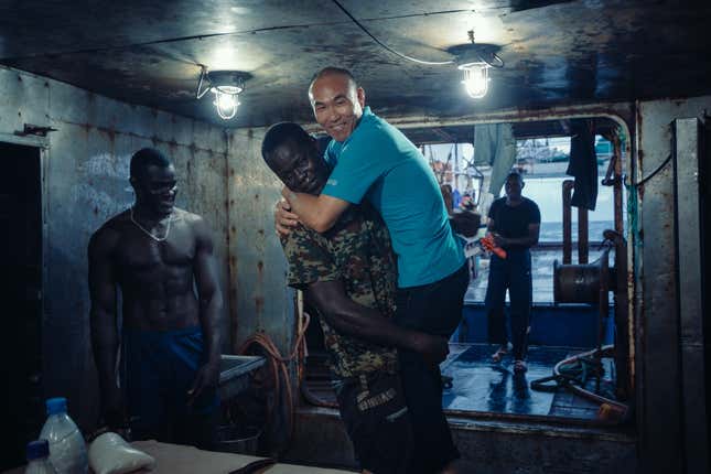 Chinese and local sailors take a break between shifts on board a fishing vessel off the coast of Guinea Bissau.