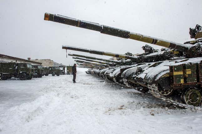 An Ukrainian Military Forces serviceman stands in front of tanks of the 92nd separate mechanized brigade of Ukrainian Armed Forces, parked in their base near Klugino-Bashkirivka village, in the Kharkiv region