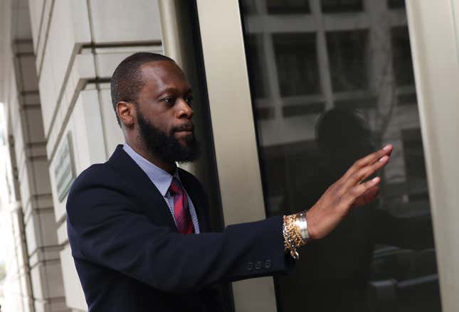 Pras Michal dressed in a dark suit enters a US district court.