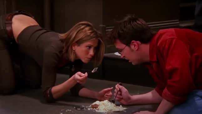 Screenshot of Rachel and Chandler from "Friends" eating cheesecake off of ground