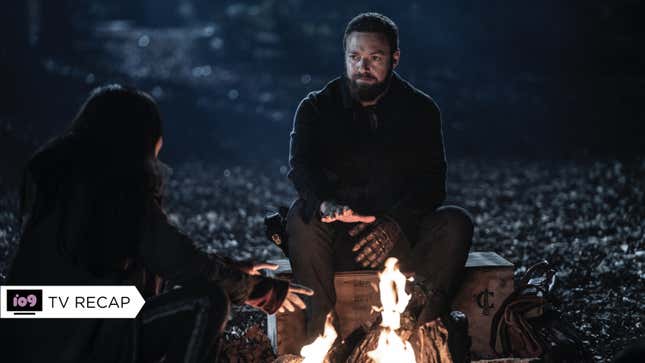 Aaron gives Lydia a disbelieving stare as they sit around a small campfire.