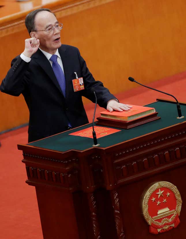 Newly elected Chinese Vice President Wang Qishan with his hand on the Constitution takes the oath at the fifth plenary session of the National People's Congress (NPC) at the Great Hall of the People in Beijing, China March 17, 2018.