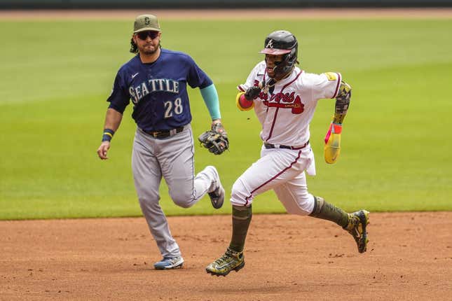 May 21, 2023; Cumberland, Georgia, USA; Atlanta Braves right fielder Ronald Acuna Jr. (13) runs past Seattle Mariners third baseman Eugenio Suarez (28) on his way to scoring a run during the first inning at Truist Park.