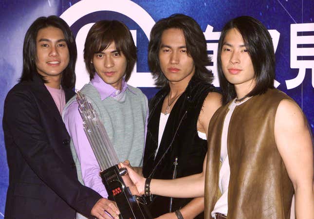 Members of Taiwan music group F4 (L-R) Ken Zhu, Vic Zhou, Jerry Yan and Vanness Wu hold souvenirs during a news conference in Hong Kong March 8, 2002. F4 will stay in town for five days to meet their fans. Their latest album "Meteor Rain" has achieved 1 million copies in countries throughout the Asia region.