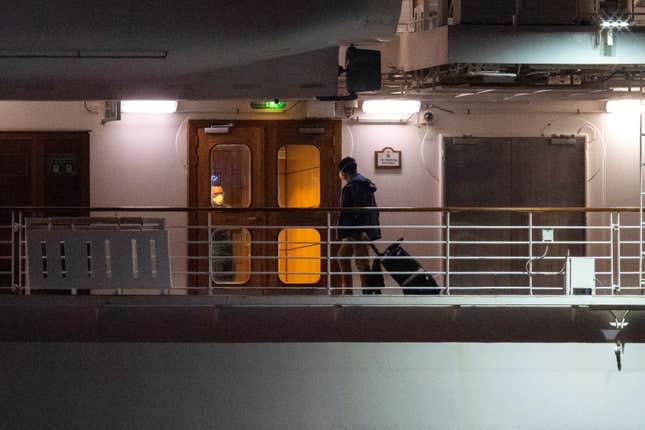 A passenger with his belongings is seen before the evacuation of the U.S. passengers of the Diamond Princess cruise ship, where dozens of passengers tested positive for coronavirus, as they arrive at Daikoku Pier Cruise Terminal in Yokohama, south of Tokyo, Japan, February 16, 2020. REUTERS/Athit Perawongmetha – RC2S1F9TDLG6