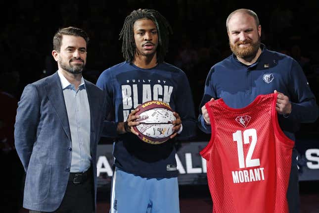 Feb 16, 2022; Memphis, Tennessee, USA; Memphis Grizzles guard Ja Morant (middle) receives a memorial game ball and jersey from general manager Zach Kleiman (left) and head coach Taylor Jenkins, for being selected to the All-Star Game, at FedExForum.