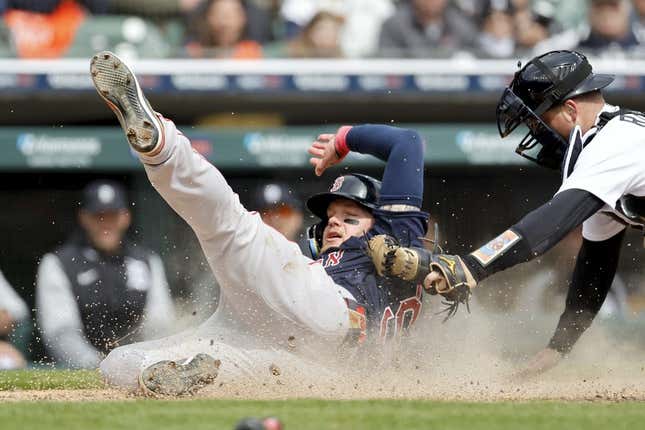 Apr 6, 2023; Detroit, Michigan, USA; Boston Red Sox right fielder Alex Verdugo (99) slides in safe at home ahead of the tag by Detroit Tigers catcher Jake Rogers (34) in the sixth inning at Comerica Park.