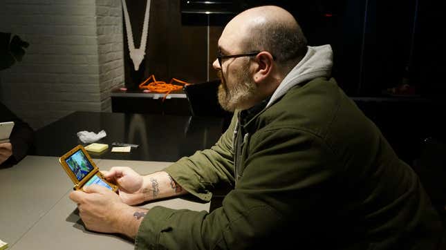 Mike Fahey of Kotaku, holding a 3DS while looking toward the left.