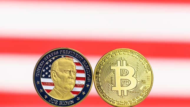 A coin reading United States President Election Joe Biden next to a gold bitcoin on a backdrop of an American flag.
