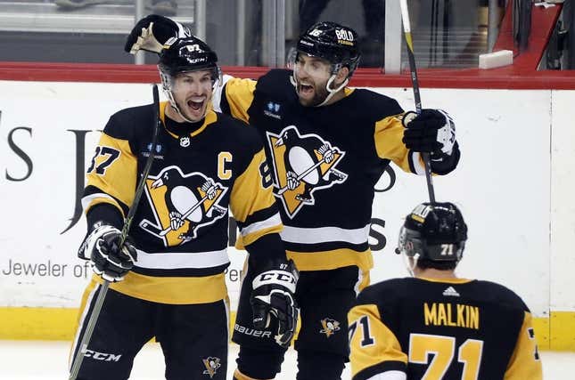 Mar 7, 2023; Pittsburgh, Pennsylvania, USA;  Pittsburgh Penguins center Sidney Crosby (87) reacts with left wing Jason Zucker (16) and center Evgeni Malkin (71) after scoring the game winning power play goal in overtime against the Columbus Blue Jackets at PPG Paints Arena. Pittsburgh won 5-4 in overtime.