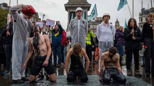 Extinction Rebellion protesters douse themselves in fake oil in London’s Trafalgar Square.