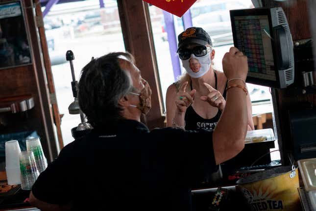A restaurant guest wears a facemask with Dr. Anthony Fauci, director of the National Institute of Allergy and Infectious Diseases, as Fish Tails bar and grill opens for in-person dining, amid the coronavirus pandemic, on May 29, 2020 in Ocean City, Maryland