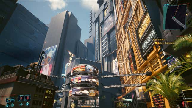 The player looks up at tall skyscrapers and advertisements in Cyberpunk 2077.