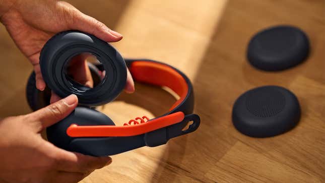 A user demonstrating how the Logitech Zone Learn's earcups can be easily removed and swapped.