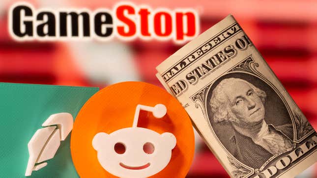 A 3d printed Robinhood and Reddit logos are seen near one dollar banknotes in front of displayed GameStop logo