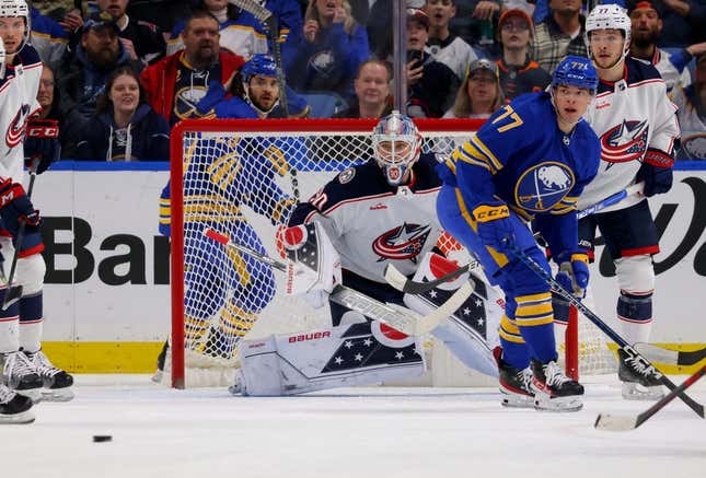 Feb 28, 2023; Buffalo, New York, USA;  Columbus Blue Jackets goaltender Elvis Merzlikins (90) and Buffalo Sabres right wing JJ Peterka (77) look for the puck during the first period at KeyBank Center.