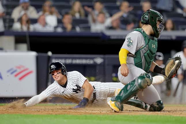 May 9, 2023; Bronx, New York, USA; New York Yankees shortstop Anthony Volpe (11) scores against Oakland Athletics catcher Shea Langeliers (23) on a sacrifice fly by Yankees right fielder Aaron Judge (not pictured) during the eighth inning at Yankee Stadium.
