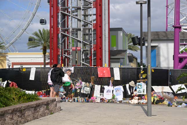 People visit a makeshift memorial for Tyre Sampson outside the Orlando Free Fall ride at the ICON Park entertainment complex, Wednesday, April 20, 2022, in Orlando, Fla. Sampson, a teenager visiting from Missouri on spring break, fell to his death while on the ride. 