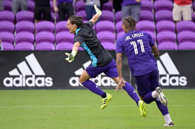 Orlando City defender Rodrigo Schlegel, left, celebrates after blocking the final New York City FC penalty kick during overtime of an MLS soccer playoff match.