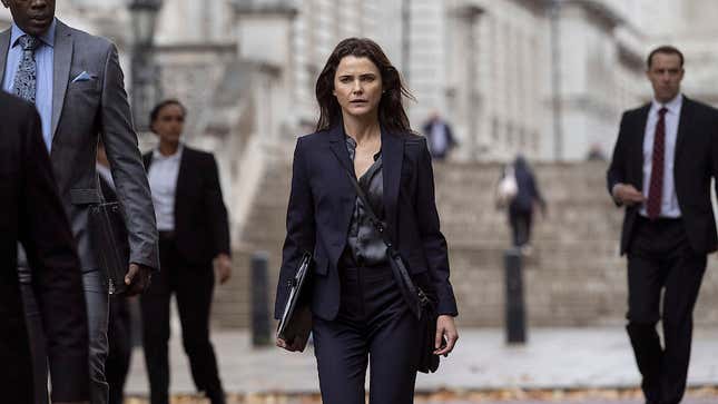 A screenshot from Netflix's The Diplomat of Keri Russell in a business suit standing isolated in front of a government building