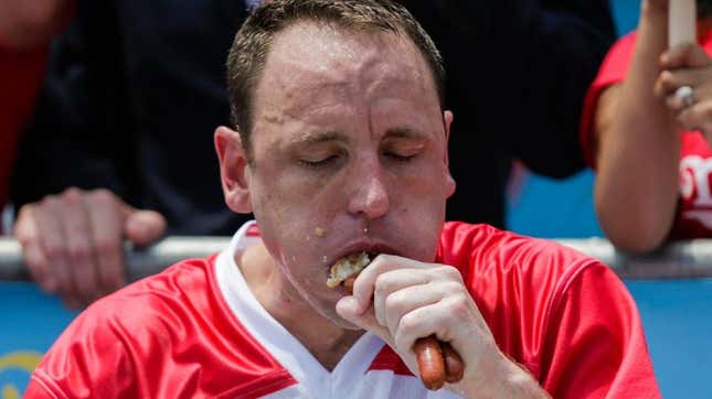 Joey Chestnut shoving a hot dog into his mouth during the Nathans July 4th Hot Dog eating contest