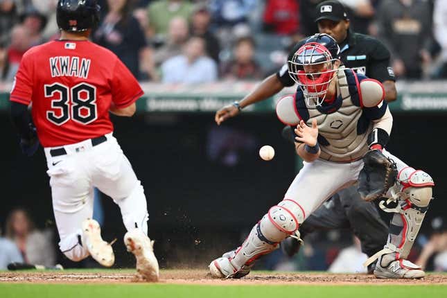 Jun 7, 2023; Cleveland, Ohio, USA; Boston Red Sox catcher Connor Wong (12) waits for the ball as Cleveland Guardians left fielder Steven Kwan (38) scores during the fifth inning at Progressive Field.