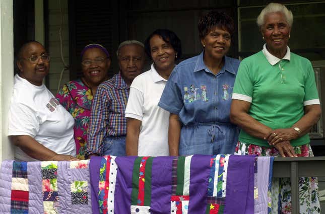 Nancy Pettway, left, Queenie Pettway, Allie Pettway, Lola Pettway, Lucy Marie Mingo and Arlonzia Pettway pose with their quilts on the porch of a Gees Bend, Ala., home, Thursday, May 15, 2003 following a show at the Whitney Museum in New York. 