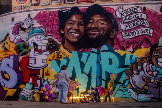  A woman looks at a mural by the artists Muck Rock and Mr79lts showing Kobe Bryant and his daughter Gianna Bryant, who were killed with seven others in a helicopter crash on January 26, in Los Angeles on January 27, 2020. 