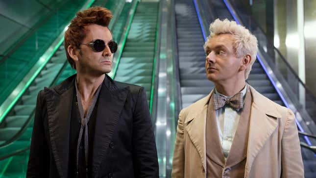 Screenshot of Michael Sheen and David Tennent as Aziraphale and Crowley standing at the foot of two escalators in different colors 