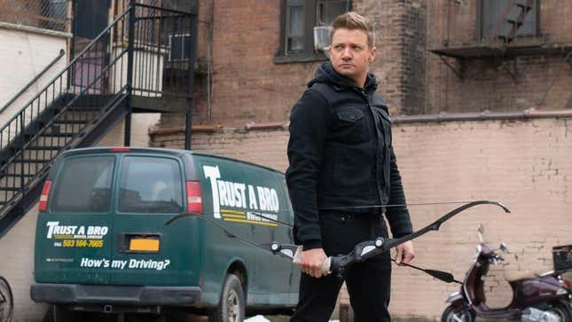 Hawkeye (Jeremy Renner) looks serious standing with his bow and arrow in hand and a green van next to him that says TRUST A BRO
