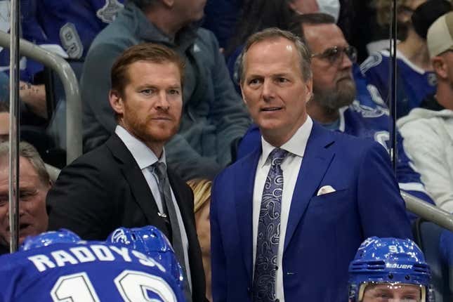 Tampa Bay Lightning head coach Jon Cooper (r.) talks to assistant coach Jeff Halpern (l.) during the second period of a game against the San Jose Sharks on Feb. 1, 2022.