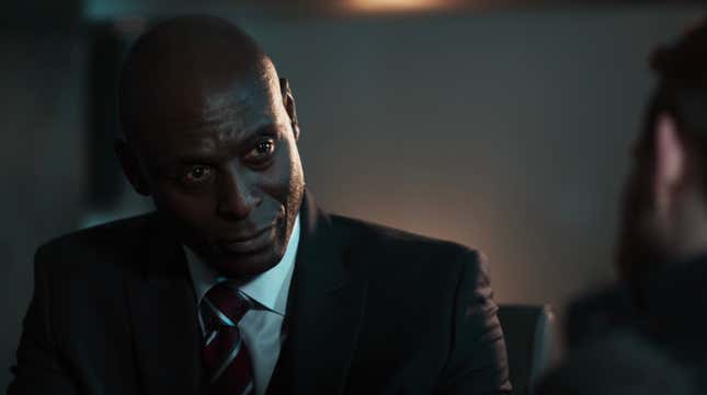 Lance Reddick as Martin Hatch in Quantum Break is sitting across from someone, looking at them intensely.