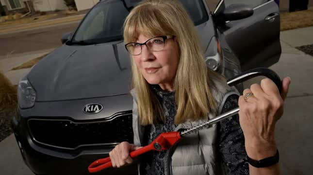A woman prepares to attempt to secure her Kia using the Club steering wheel lock. 