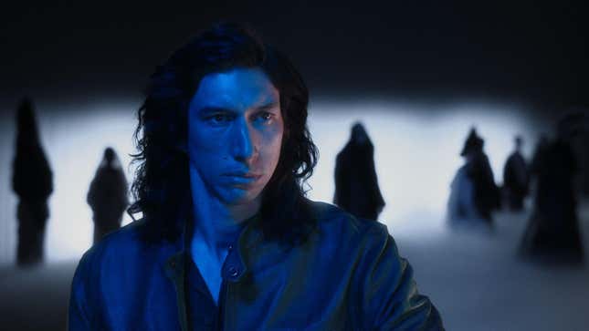 A screenshot of Adam Driver shot in a blue filter and surrounded by shadowy figures from the movie Annette