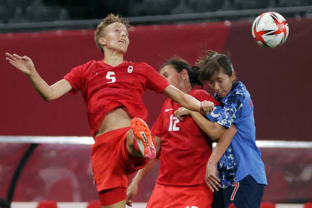 Canada's midfielder Quinn (L) heads the ball during the Tokyo 2020 Olympic Games women's group E first round football match between Japan and Canada at the Sapporo Dome in Sapporo on July 21, 2021.