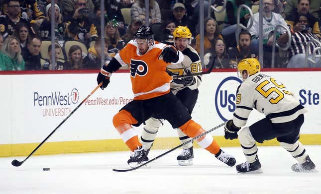 Mar 11, 2023; Pittsburgh, Pennsylvania, USA;  Philadelphia Flyers center Kevin Hayes (13) reaches for the puck against Pittsburgh Penguins center Sidney Crosby (87) and left wing Jake Guentzel (59) during the first period at PPG Paints Arena.